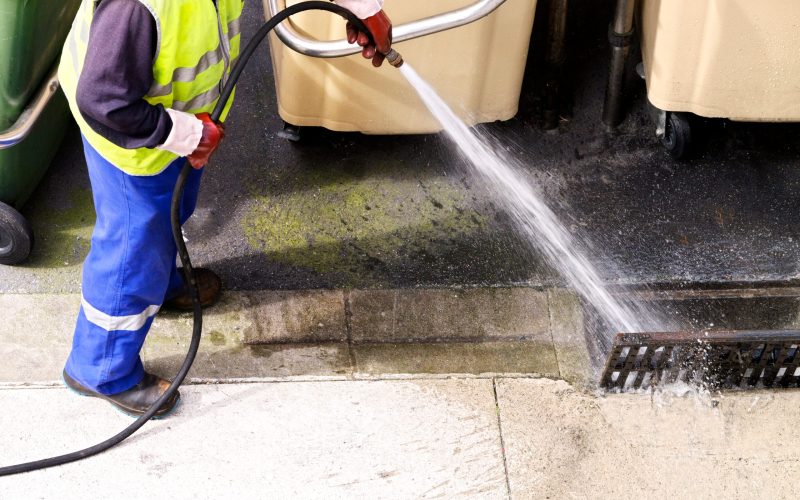 sewer line drainage  by professional  workers with hose and pressurized water of service truck