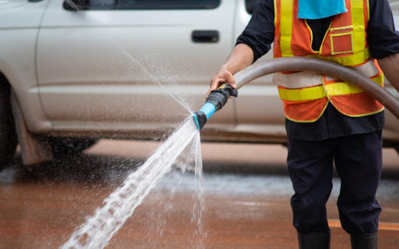 Wet cleaning of street with pressurized water.